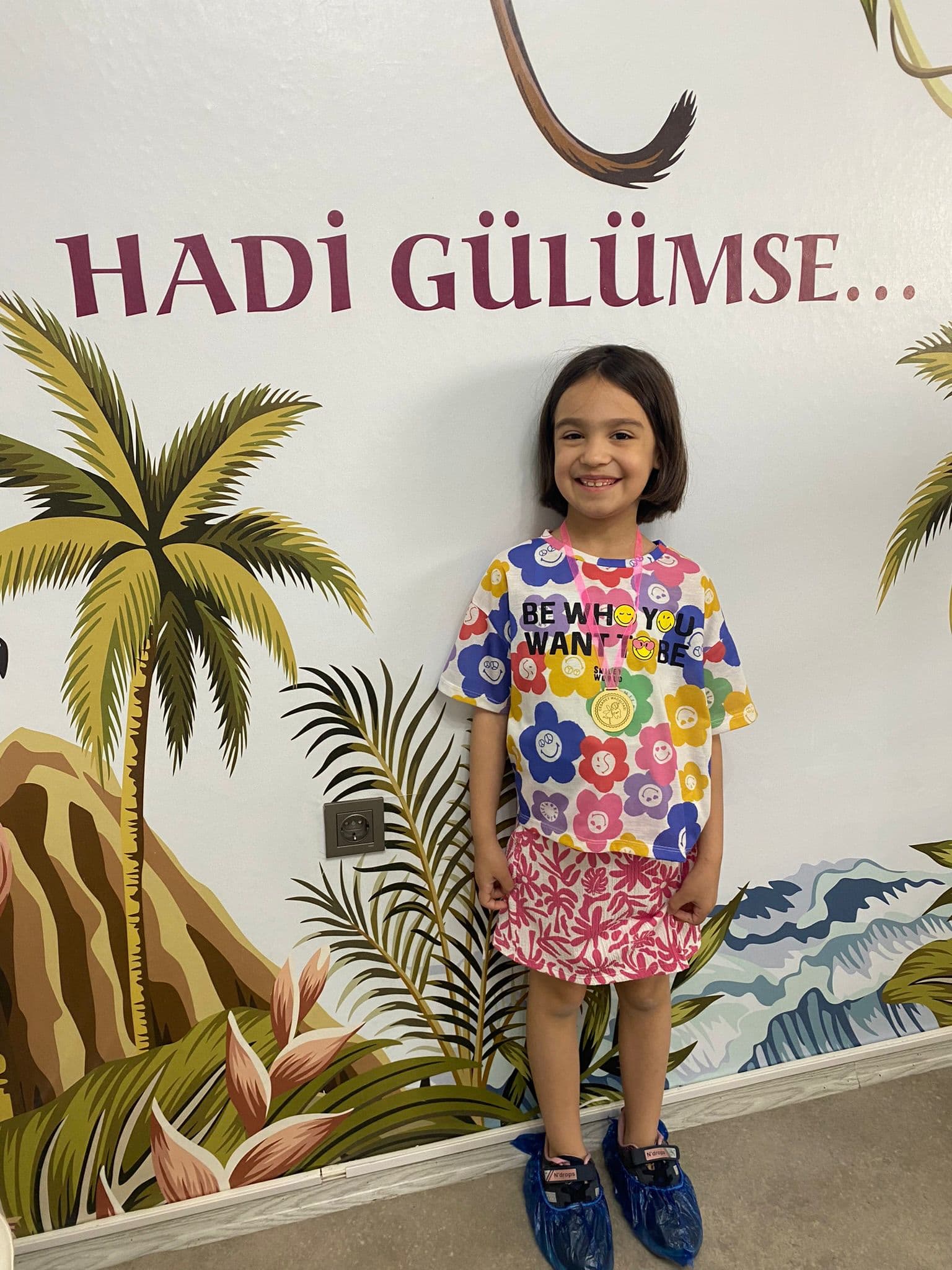 Klinik oyunlu duvarı önünde gülen çocuk